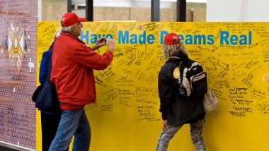 Rotarians make donations to End Polio Now and sign the I Have Made Dreams Real wall.