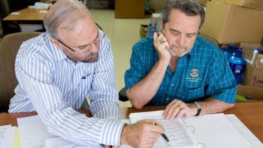 Rotarian and a member of the Humanitarian Grants Cadre of Technical Advisers Michael Barrington review grant materials.