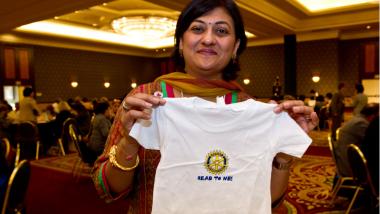 Sonal Sanghvi shows a shirt that is part of a literacy kit and book donation service project.