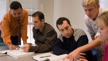 A group of people discussing topics around a table.